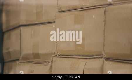 Cardboard boxes stacked inside distribution warehouse close up. Stock Photo