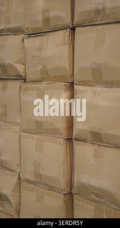 Cardboard boxes stacked inside warehouse behind reflection window close up. Stock Photo