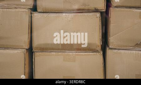 Cardboard boxes stacked in a warehouse closeup. Stock Photo