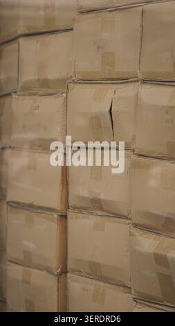 Cardboard boxes stacked inside distribution warehouse close up. Stock Photo