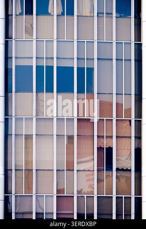 Modern office building facade close-up with minimalist vertical frames and colorful color-blocked windows Stock Photo