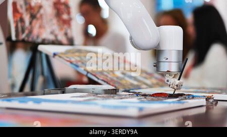 Futuristic robotic arm painting on canvas. Artificial intelligence creating art, modern technology concept Stock Photo