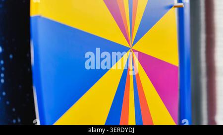 Colorful radiating lines in a geometric sunburst design. Vibrant abstract art in yellow, blue and pink Stock Photo