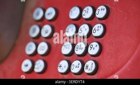 Red vintage payphone keypad showing braille numbers for accessible communication Stock Photo