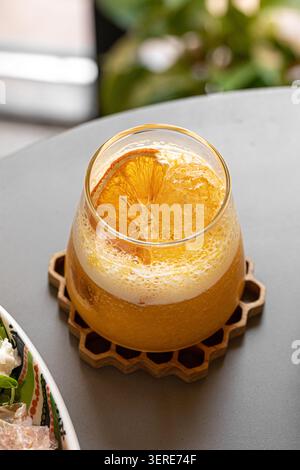 Fresh orange cocktail on a honeycomb coaster Stock Photo
