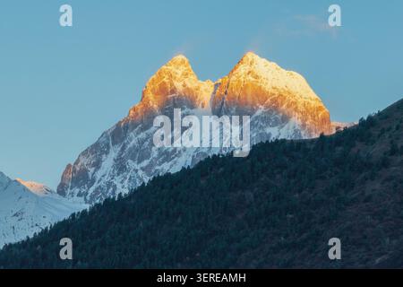 Sunrise at Ushba mountain. Beautiful shinning mountain peak range. Georgia. Stock Photo