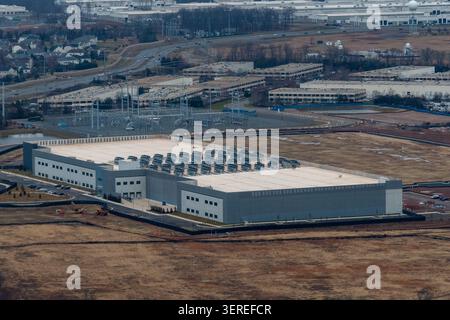 Aerial view of hyperscale data center facility showing rooftop cooling infrastructure and adjacent electrical substation for AI and AWS Stock Photo