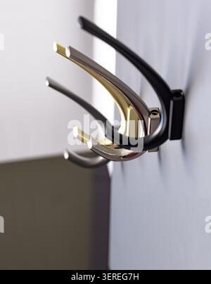 Wall hooks are mounted on the wall, showing different colors. They can hold various items like coats, hats, or bags. This setup is common in homes and Stock Photo