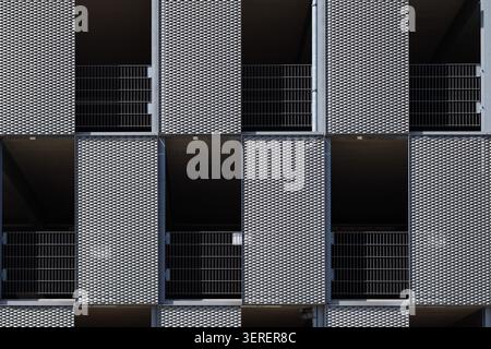 Abstract modern building facade with geometric metal panels and repeating architectural pattern Stock Photo