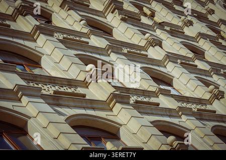A close-up view of an ornate building facade in Baku, Azerbaijan, featuring light-colored stone, arched windows, and intricate decorative patterns. St Stock Photo