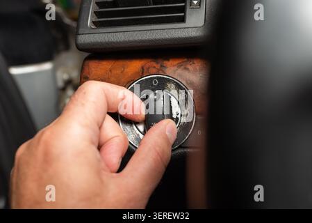 Driver hand operating the headlight control switch in a old car. Stock Photo