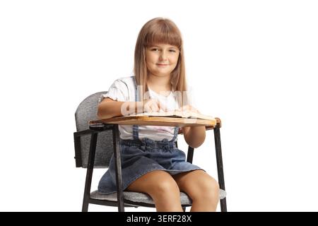 Girl sitting in a school chair isolated on white background Stock Photo