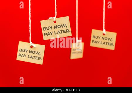 Hanging price tags with text BUY NOW, PAY LATER. Consumer debt, e-commerce trends, and purchasing behavior concept. Stock Photo