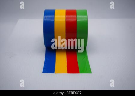 Vibrant multicolored duct tape rolls in a row extending parallel lines on white surface Stock Photo