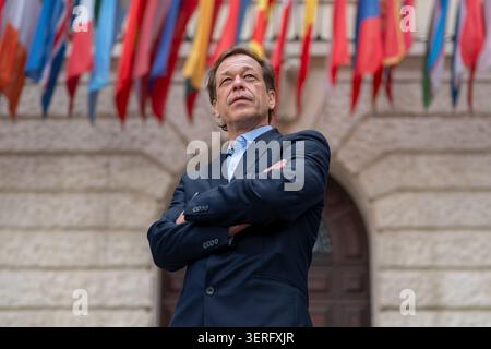 Mature man in a business jacket against international national flags Stock Photo