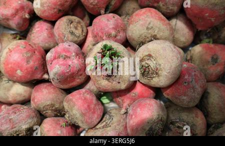 Red beetroot tubers on sale at the rural market. Top view, closeup. Stock Photo