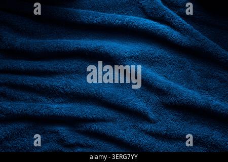 Soft blue terry towel fabric texture with dramatic shadows and wavy folds. Stock Photo
