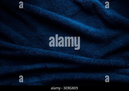 Soft blue terry towel fabric texture with dramatic shadows and wavy folds. Stock Photo