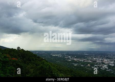 High angle view of cityscape under thick overcast dark clouds and rain curtain Stock Photo