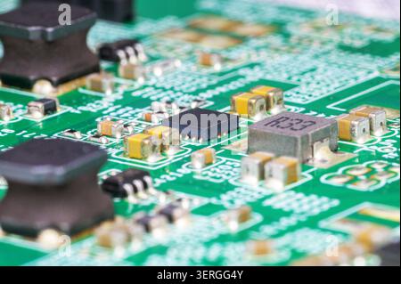 Close-up macro shot of various electronic components on a green printed circuit board. Stock Photo
