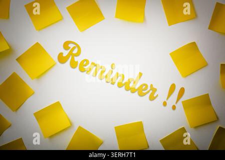 Yellow sticky notes frame the word “Reminder!” on a clean white background, symbolizing memory, organization, planning, and important tasks. Stock Photo