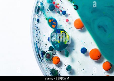 Modern abstract composition featuring floating blue and orange spheres surrounded by fluid textures on a clean white background. Suitable for technolo Stock Photo