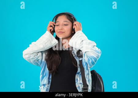 Young woman listening to music wearing headphones in studio Stock Photo