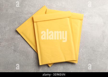 Stack of yellow envelopes on grey table, top view Stock Photo