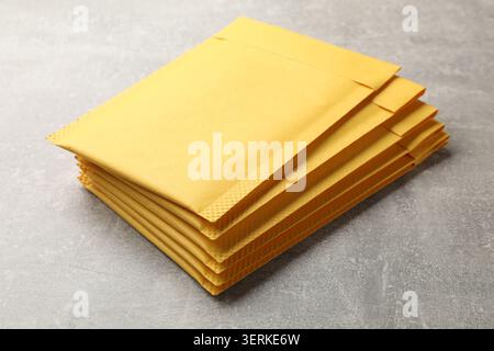 Stack of yellow envelopes on grey table, closeup Stock Photo