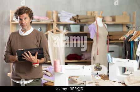 Man tailor makes pattern using tablet Stock Photo