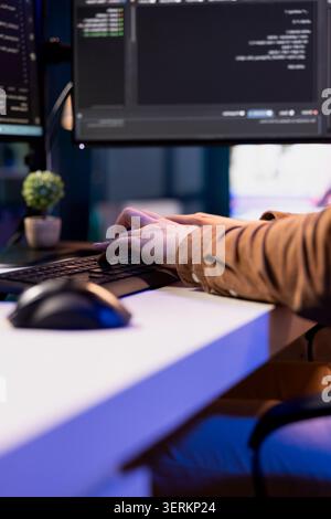 Teleworking programmer securing company servers from virus attacks to avoid unwanted failures. IT remote employee writing code to build firewalls protecting data from threats, close-up shot. Stock Photo