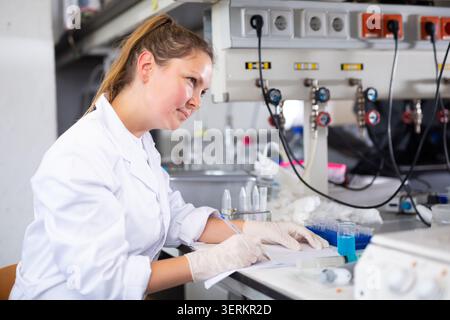 Portrait of adult woman scientist taking notes in laboratory Stock Photo