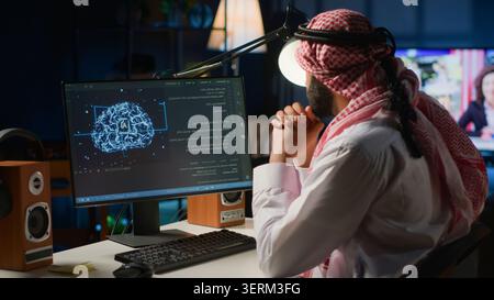 Arab admin using computer to visualize artificial intelligence neural networks made up of interconnected nodes using augmented reality technology. Developer oversees AI systems processing information. Stock Photo