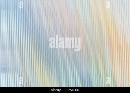 A vibrant abstract background composed of vertical lines in a soft, iridescent spectrum of blue, yellow, green, and orange, creating a light-refractiv Stock Photo