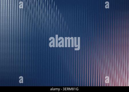 An abstract background with a vertical ribbed texture, transitioning from a deep blue on the left to a subtle pinkish hue on the right side. Stock Photo