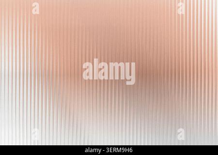 An abstract textured background featuring vertical ribbed lines with a soft, glowing rose gold and white gradient effect. Stock Photo