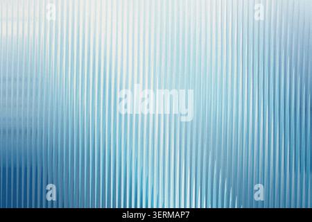 An abstract background composed of vertical lines with a subtle gradient of light and dark blue, creating a clean and refreshing aesthetic. Stock Photo