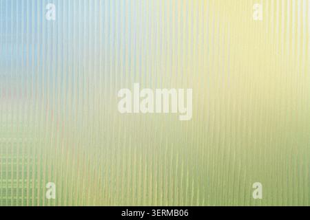 An abstract, textured background featuring a pattern of vertical lines with a soft, bright light effect transitioning from green to yellow. Stock Photo