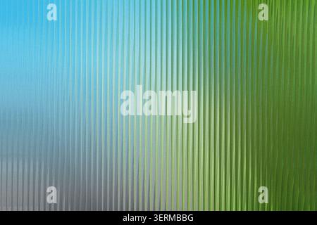 An abstract background featuring vertical ribbed lines with a vibrant blue to green color gradient transition. Stock Photo