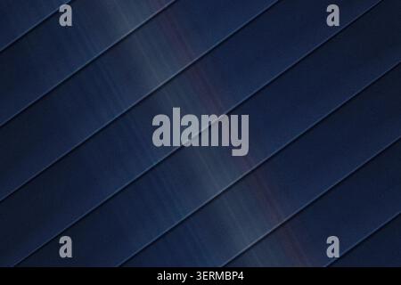 A sophisticated abstract background featuring dark blue diagonal stripes with a subtle light streak and a fine grainy texture, creating a modern look. Stock Photo