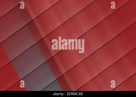 A sophisticated abstract background featuring diagonal stripes in varying shades of deep red and maroon, featuring a subtle grainy texture. Stock Photo
