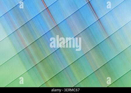 An abstract digital art background featuring parallel diagonal lines overlaid on a vibrant blue and green gradient with a subtle grainy texture. Stock Photo