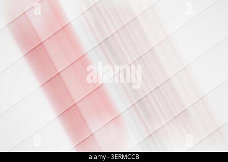 A minimalist abstract composition featuring diagonal stripes intersecting a soft, vertical red light beam, set against a pure white background. Stock Photo