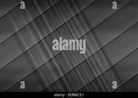 A dark, moody abstract background with diagonal stripes and vertical light streaks, featuring a textured, grainy finish. Stock Photo