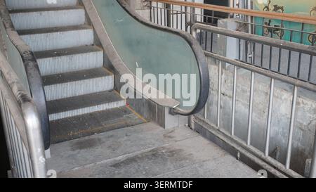 Non-working dusty escalator at Mandalay Railway Station, Myanmar, inside an empty train station showing aging transport infrastructure. Stock Photo