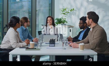 Diversity business team talking brainstorming with laptop and stats papers at office meeting in boardroom. Multiracial businesspeople colleagues talk Stock Photo