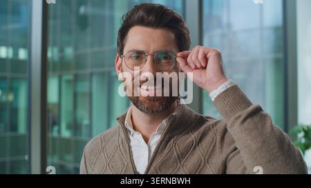 Portrait Caucasian business man looking at camera holding glasses smiling toothy happy in office adult businessman male employer look hold eyeglasses Stock Photo