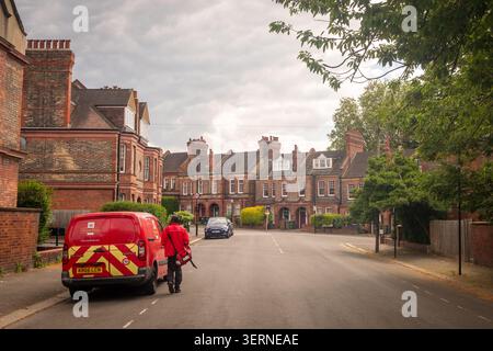 LONDON - MAY 07, 2026: Royal Mail Postman – Postman delivering mail on a quiet Victorian residential street in Streatham Hill. Stock Photo