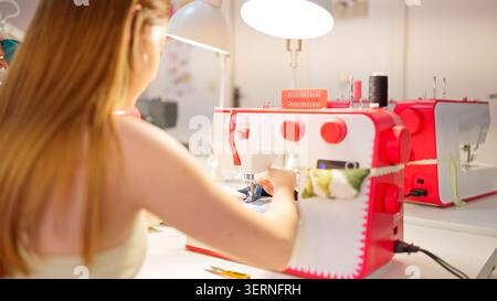Woman working with sewing machine in craft workshop Stock Photo