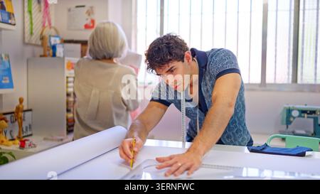 Young tailor designing a pattern in sewing studio Stock Photo
